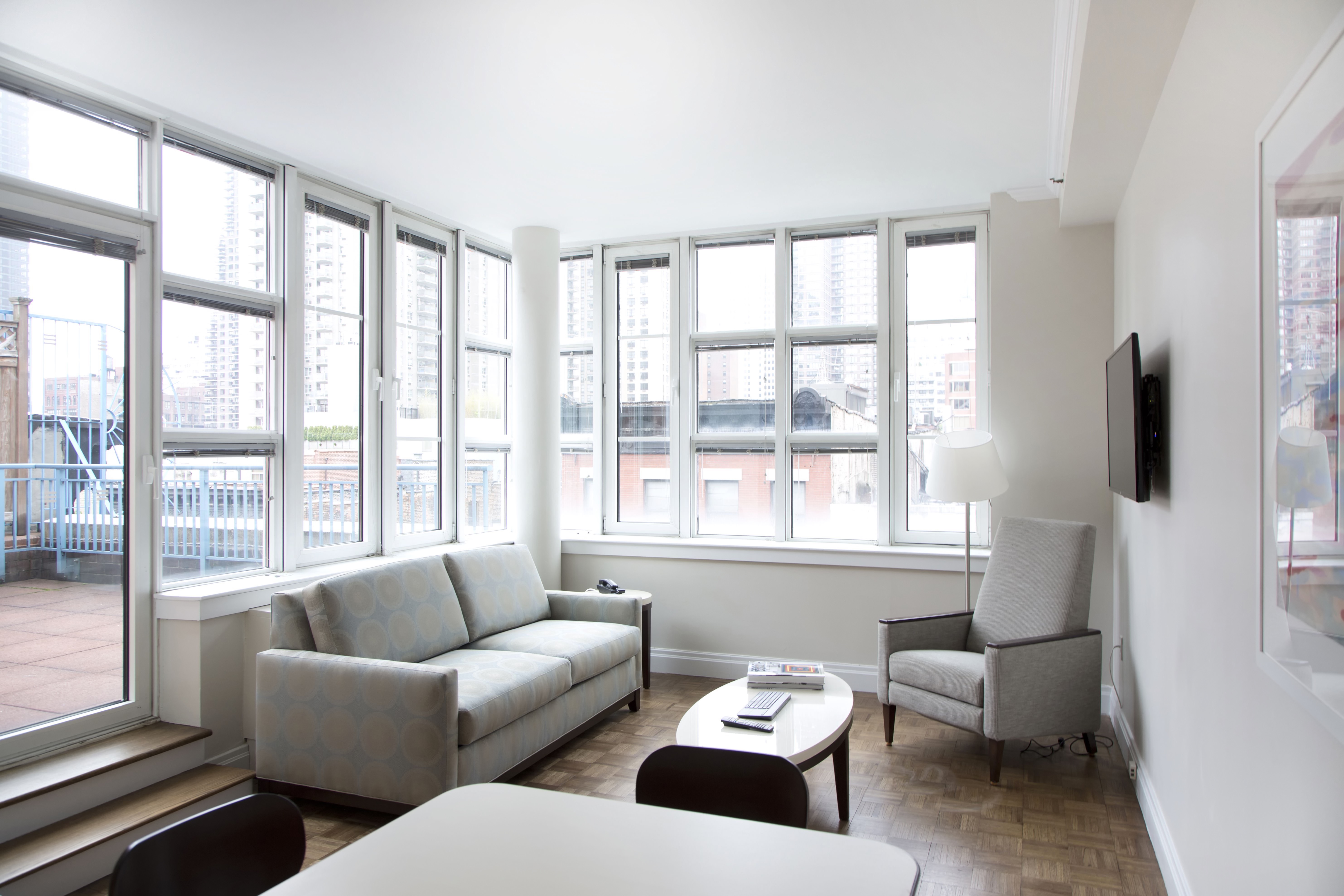 Bright, white waiting room with windows, furniture and television
