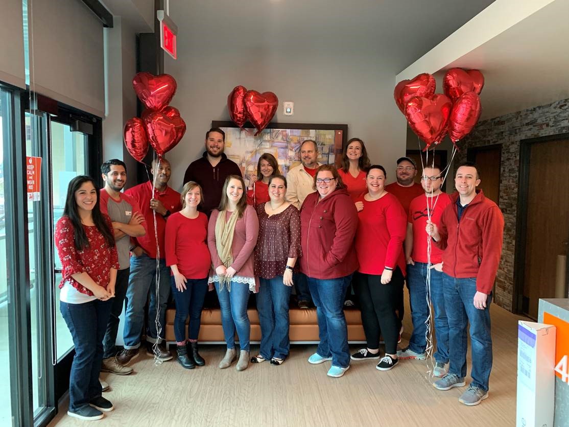 Fort Worth team wearing red shirts holding balloons