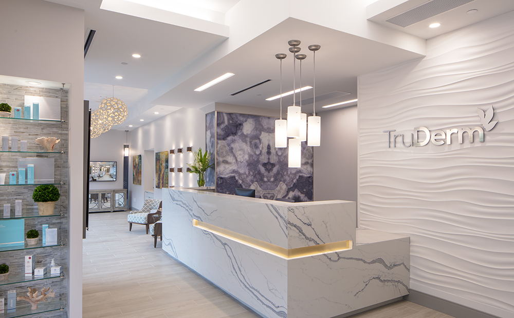 Dermatologist reception area with modern decor and products on shelves