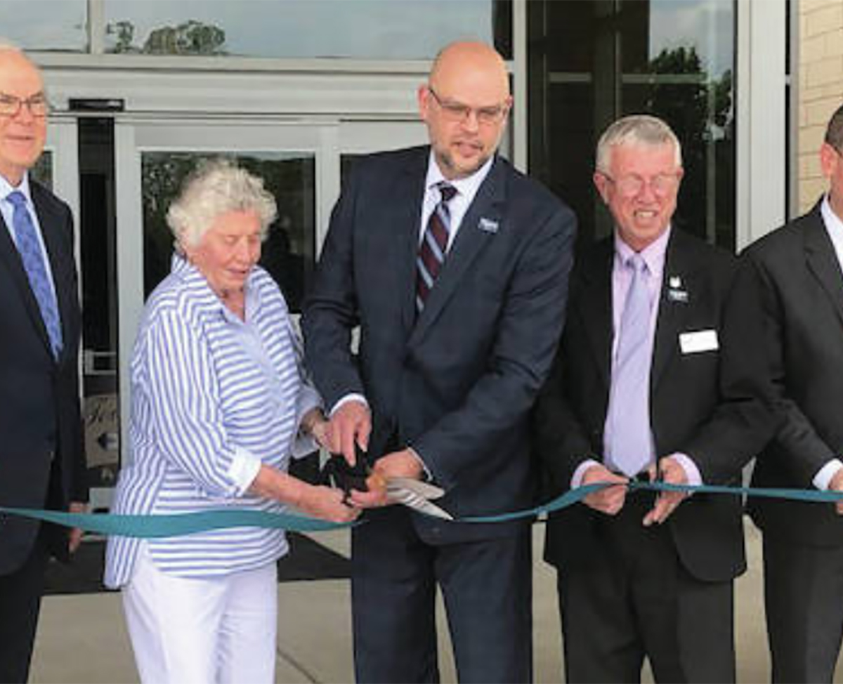 Kettering Health Network officials cut the ribbon on Troy Hospital while standing by its front doors wearing business attire