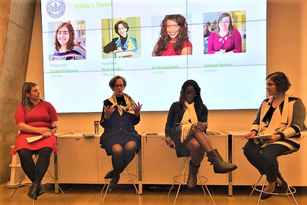 Four women on stage seated in chairs with video screen behind them at USGBC Women in Green panel discussion